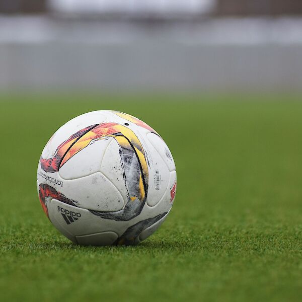 Adidas soccer ball on a grass pitch. Photo by Peter Glaser, Unsplash.